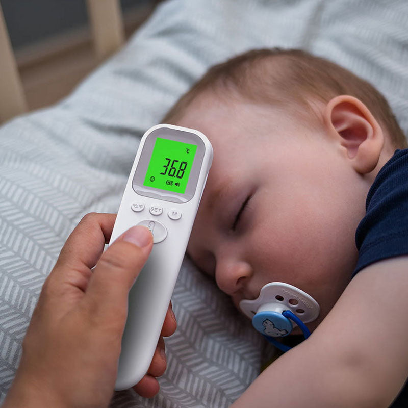 User holding forehead thermometer ready to take temperature
