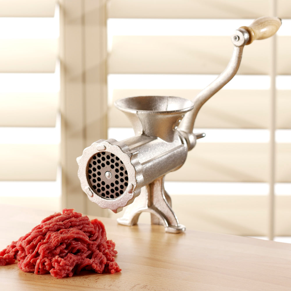 Manual meat grinder showing screw clamp fixing to bench