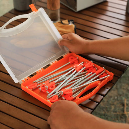 Steel tent peg being used on grassy ground