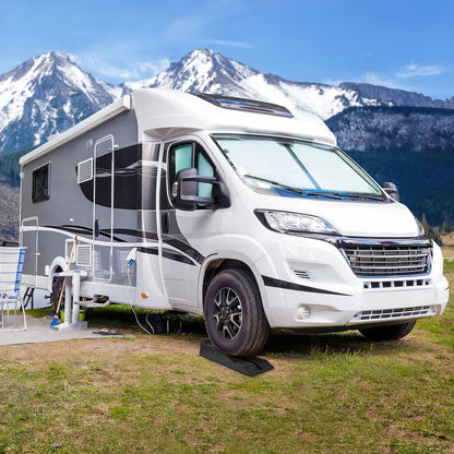 Camper wheel chocks placed under caravan tyre for stability