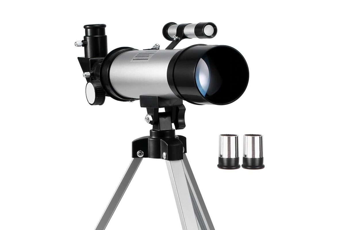 Side view of astronomical telescope with tripod in silver