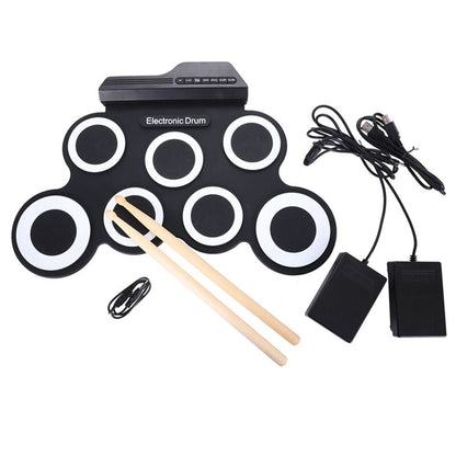 Electronic roll up drum kit with drum sticks resting on the pads
