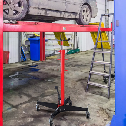 Transmission jack lifting a vehicle component in workshop