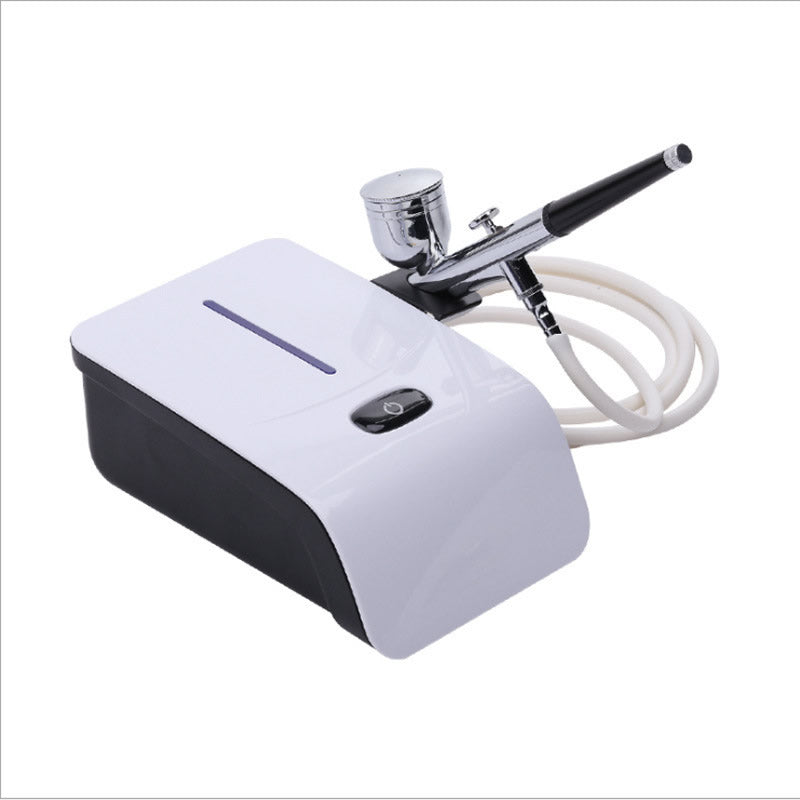Side angle of mini air brush compressor with hose attached