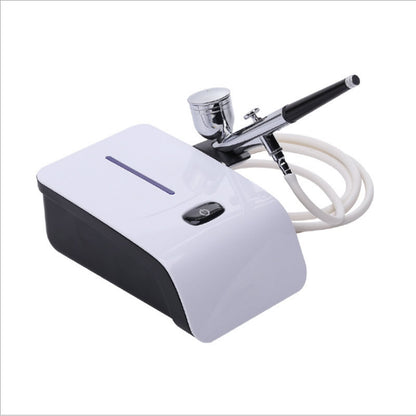 Side angle of mini air brush compressor with hose attached