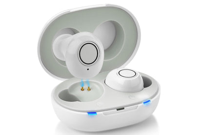 Hearing aids placed next to user manual and cleaning tool