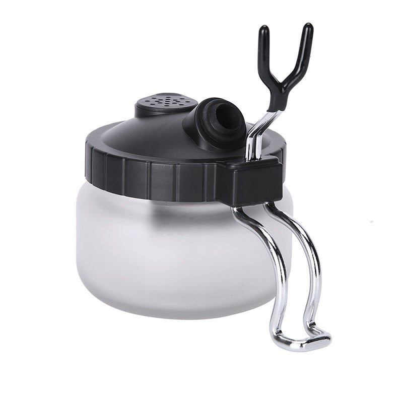 Side angle of airbrush cleaning pot with integrated airbrush hanger