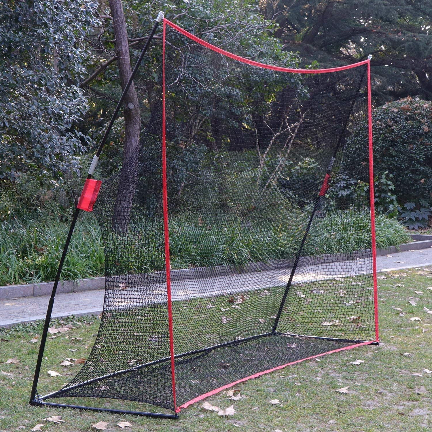 Golf practice net with four stakes securing it to ground