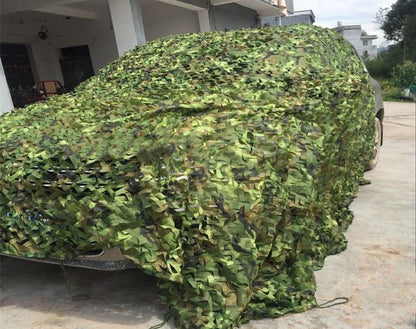 Camo net covering a vehicle for camouflage in forest